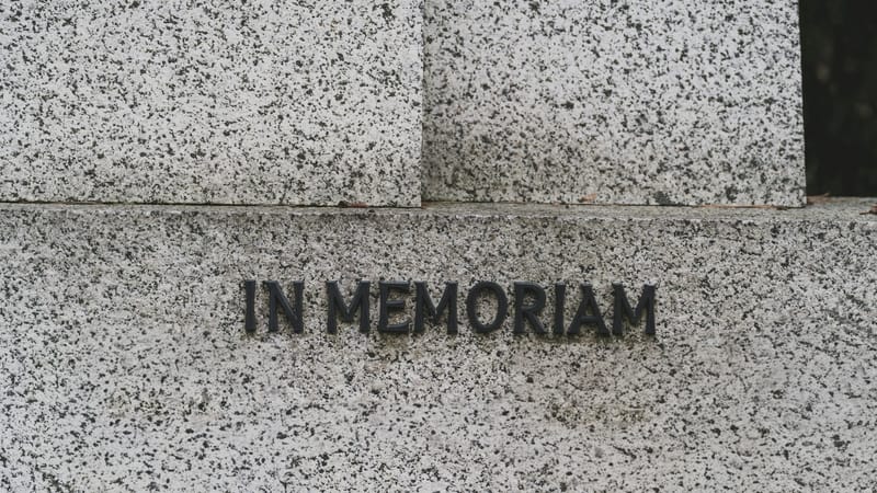 A granite monument with the words In memoriam cut into the stone